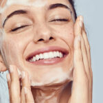 Woman washing face with skincare cleanser highlighting barrier-safe renewal